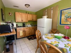 a kitchen with a table and a white refrigerator at One Bed Suite near Beaches and Downtown Sarasota in Sarasota