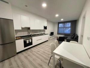 eine Küche und ein Wohnzimmer mit einem Tisch und einem Sofa in der Unterkunft Apartamento Roncudo Planta Baja in A Coruña