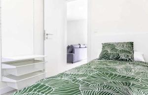 Schlafzimmer mit einem Bett mit einer grünen und weißen Bettdecke in der Unterkunft Apartamento Roncudo Planta Baja in A Coruña