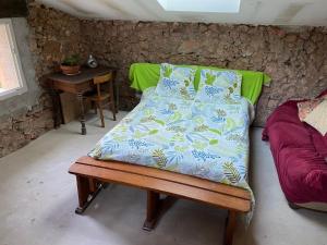 a bed in a room with a table and a chair at RELAIS EQUESTRE DE LA CHEVALIERE SAUVAGE in Tourves
