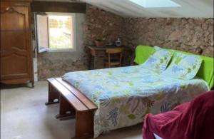 a bedroom with a bed and a table and a window at RELAIS EQUESTRE DE LA CHEVALIERE SAUVAGE in Tourves