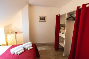 a bedroom with a bed and a closet with red curtains at Le Pont Royal in Amboise