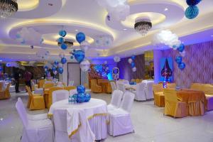 a banquet hall with white tables and chairs and balloons at Hotel The Spades in Zirakpur