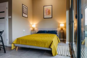 雅羅斯瓦夫的住宿－APARTAMENTY PRUCHNICKA，一间卧室配有一张带黄色床罩和两盏灯的床。