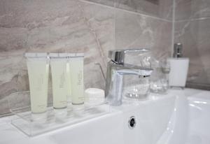 a bathroom sink with a faucet and two cups on it at Apartment 4 You in Split in Split