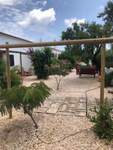 a garden with a wooden pergola and some plants at Quinta das Amendoeiras B&B in Nora