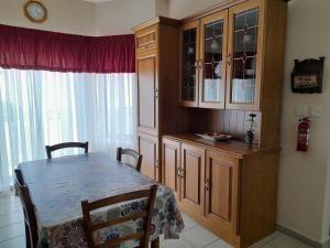 une salle à manger avec une table et une armoire en porcelaine dans l'établissement Silver Shadow Holiday Maisonette, à Marsaxlokk