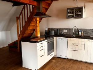 a kitchen with white cabinets and a wooden staircase at Grosse-Schwalbe in Kabelhorst