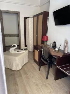 een hotelkamer met een bureau, een bed en een computer bij Sweet Dreams in San Vito lo Capo