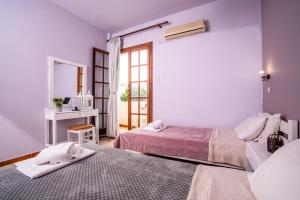a room with two beds and a sink and a mirror at Alexandra Apartments in Stalida