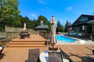 a patio with an umbrella and a pool and a house at Blue Mountain at your Door Step in Blue Mountains