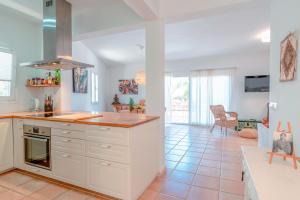 a kitchen with white cabinets and a tile floor at Sunset SPA Villa Cala Tarida in Sant Josep de sa Talaia +19 photos