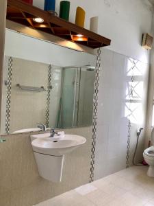 a bathroom with a sink and a mirror and a toilet at City Pass Da Lat in Da Lat