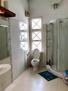 a bathroom with a toilet and a shower and a sink at City Pass Da Lat in Da Lat