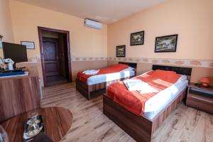 Cette chambre comprend 2 lits et une télévision. dans l'établissement Panoráma Hotel, à Békéscsaba