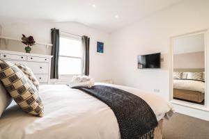 1 dormitorio con cama y espejo en Modern & spacious 1 bedroom Clapham Junction flat, en Londres