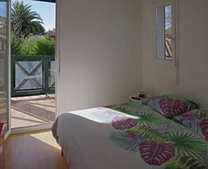 ein Schlafzimmer mit einem Bett mit einer tropischen Tagesdecke darauf in der Unterkunft not bookable in Anglet