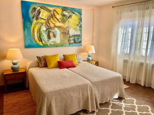 een slaapkamer met een bed en een schilderij aan de muur bij Home2Book El Encanto La Laguna Centro Histórico in La Laguna