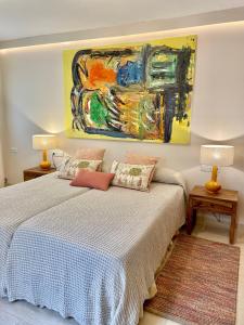 een slaapkamer met een bed met een schilderij aan de muur bij Home2Book El Encanto La Laguna Centro Histórico in La Laguna