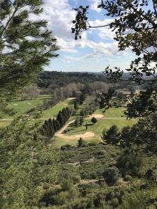 uma vista para um campo de golfe numa colina com árvores em L'Oustau L'Eucalyptus em Mouriès