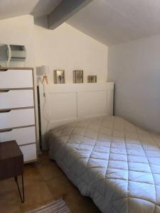 een witte slaapkamer met een bed en een dressoir bij L'Oustau L'Eucalyptus in Mouriès