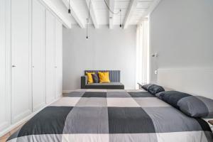 ein großes Bett in einem Zimmer mit Sofa in der Unterkunft L'Atelier del Centro: tra design, storia e fascino in Brescia