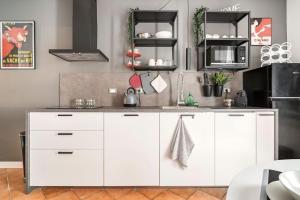 cocina con armarios blancos y nevera en L'Atelier del Centro: tra design, storia e fascino, en Brescia