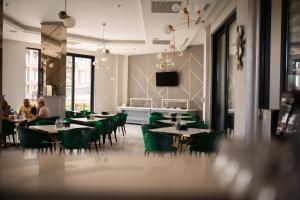 uma sala de jantar com mesas e cadeiras verdes em Hotel Grand Dedal em Mamaia Nord – Năvodari