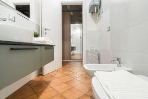 ein weißes Bad mit einem Waschbecken und einem WC in der Unterkunft L'Atelier del Centro: tra design, storia e fascino in Brescia
