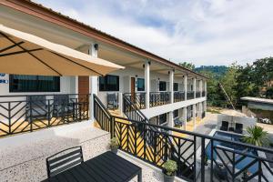 uma varanda de uma casa com uma mesa e cadeiras em The Chu’s Boutique Hotel em Khao Lak