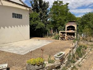 un jardín con horno de pizza en un patio en Chambres, Table d'Hôtes et Gites Les Mesanges, en Saint-Jean-de-Sauves