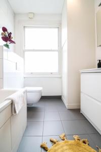 a bathroom with a window and a toilet and a sink at Modern & spacious 1 bedroom Clapham Junction flat in London