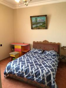 Jrvezh House في يريفان: غرفة نوم بسرير وطاولة وصورة على الحائط