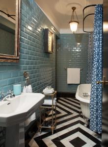 a bathroom with a white sink and blue tiles at Triana House in Seville