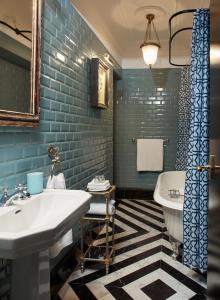 a bathroom with a white sink and blue tiles at Triana House in Seville