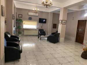 a waiting room with black chairs and a tv at Surf Hotel in Baku