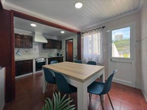 eine Küche mit einem Holztisch und blauen Stühlen in der Unterkunft Casa Mar in Ponta Delgada