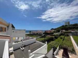 einen Blick auf ein Gebäude mit Meerblick im Hintergrund in der Unterkunft Casa Mar in Ponta Delgada