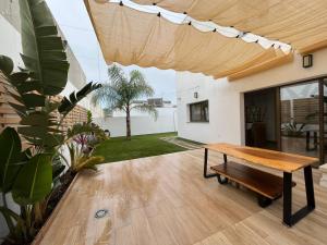 a patio with a wooden table in a house at OASIS PRESTIGIO in Huétor Vega