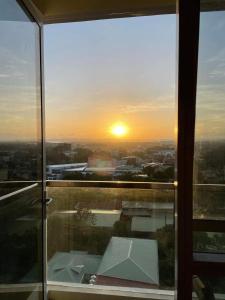 a view of a sunset from a glass window at S & E Condo with Panoramic View in Iloilo City