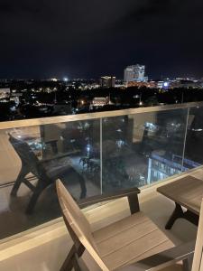 een tafel en stoelen op een balkon in de nacht bij S & E Condo with Panoramic View in Iloilo City