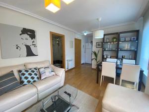 un soggiorno con divano e tavolo di Oviedo Soja City apartamento a minutos del centro a Oviedo