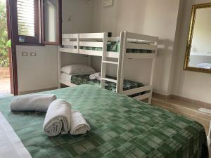 a bedroom with two bunk beds and a mirror at Tanit Hotel Villaggio Ristorante in Carbonia