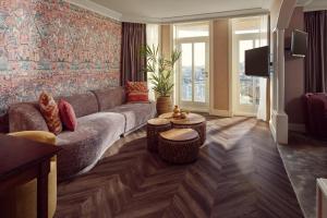 ein Wohnzimmer mit einem Sofa und einem TV in der Unterkunft Van der Valk Palace Hotel Noordwijk in Noordwijk aan Zee