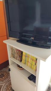 TV en un puesto de TV blanco con DVD en Appartamento vicino al mare a Scalea, en Scalea
