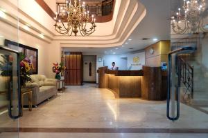 a lobby of a hotel with a man standing at a counter at Hotel Obelisco in Cali