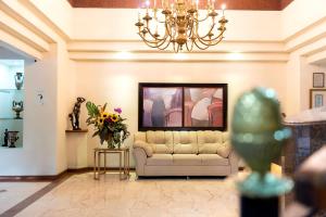 a living room with a couch and a chandelier at Hotel Obelisco in Cali