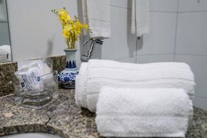 a bathroom with towels on a counter with a sink at Hotel Dan Inn Planalto São Paulo in Sao Paulo