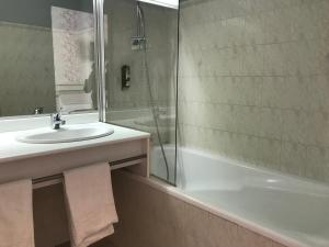 uma casa de banho com um lavatório, um chuveiro e uma banheira em Logis La Villa des Houx em Aumale
