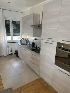 a white kitchen with a sink and a stove at Luxury center appartment in Novi Ligure +4 photos